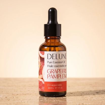 Delune Grapefruit (Pink) Pure Essential Oil, 30ml amber glass dropper bottle on warm travertine stone