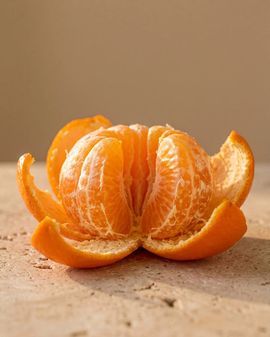 A freshly peeled mandarin with its segments glowing in warm light — the sweet, juicy citrus scent of Delune Mandarin Pure Essential Oil
