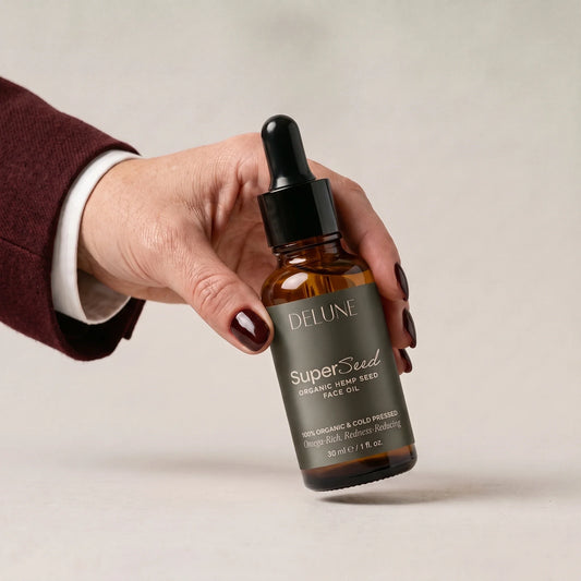 Hand picking up Delune Super Seed Hemp Seed Face Oil