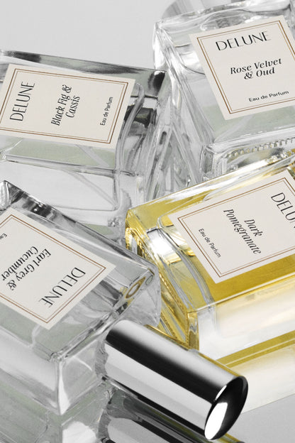 Close-up of Delune eau de parfum bottles, including Rose Velvet & Oud, with cream labels